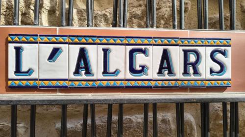 a sign on a building that says laaza at Hostal Boutique Restaurante El Algars in Caseras