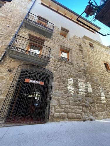 a stone building with a gate in front of it at Hostal Boutique Restaurante El Algars in Caseras