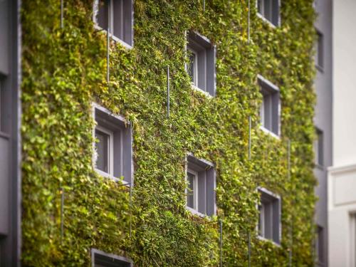 a building covered in green ivy with windows at Mercure Nantes Centre Gare in Nantes