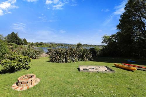 un champ avec deux kayaks sur l'herbe dans l'établissement A Lakeside Story - Lakefront at Okere Falls, à Okere Falls