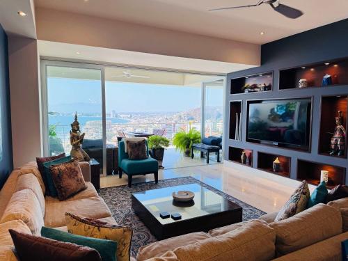 a living room with a couch and a tv at 3-Bedroom Condo in the romantic zone in Puerto Vallarta