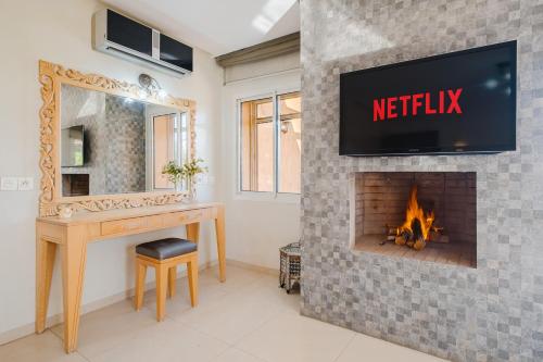 a bathroom with a fireplace with a tv above it at Villa with Private Garden & Pool Ourika, Atlas Mountains in Sidi Bouzguia