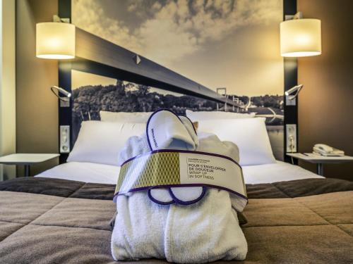 a book bag sitting on a bed in a hotel room at Mercure Cergy Pontoise Centre in Cergy