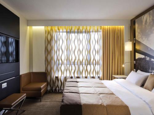 a hotel room with a bed and a window at Mercure Cergy Pontoise Centre in Cergy
