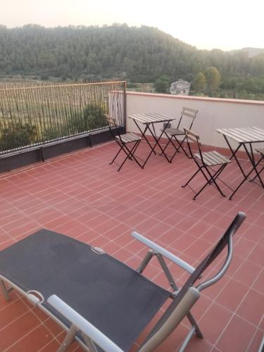 a group of tables and chairs on a patio at Hostal Boutique Restaurante El Algars in Caseras