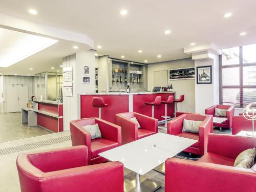 a restaurant with red chairs and a white table at Mercure Cergy Pontoise Centre in Cergy