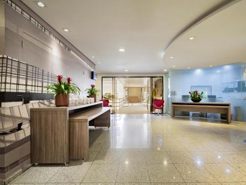 a lobby with a desk in a building at Mercure Sao Paulo Moema Times Square in Sao Paulo