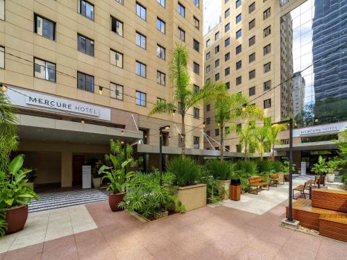 a hotel courtyard with plants in front of a building at Mercure Sao Paulo Moema Times Square in Sao Paulo
