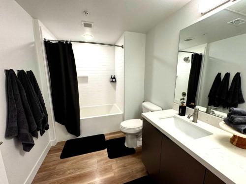 a bathroom with a sink and a toilet and a mirror at Luxury Haven 10 Min From Disneyland With Pool & GYM in Tustin