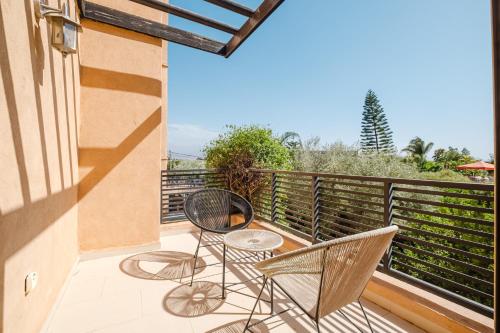 a balcony with two chairs and a table at Villa with Private Garden & Pool Ourika, Atlas Mountains in Sidi Bouzguia
