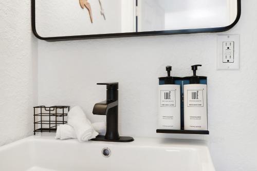 a bathroom sink with two soap bottles on it at The Victoria Hotel in Fort Lauderdale
