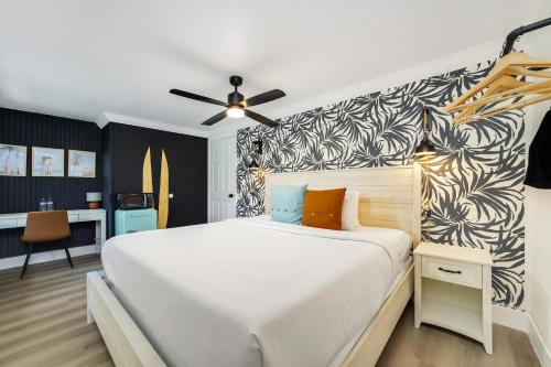 a bedroom with a large white bed and a wall at The Victoria Hotel in Fort Lauderdale