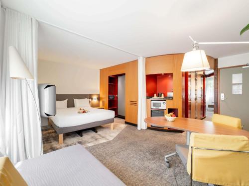 a room with a bed and a table and a kitchen at Novotel Suites Cannes Centre in Cannes