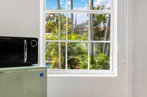 a kitchen window with a view of palm trees at The Victoria Hotel in Fort Lauderdale