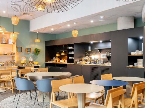 a restaurant with tables and chairs and a counter at Novotel Suites Cannes Centre in Cannes