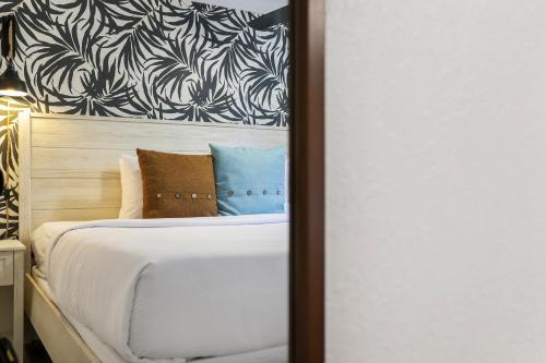 a bedroom with a large bed with a wall at The Victoria Hotel in Fort Lauderdale