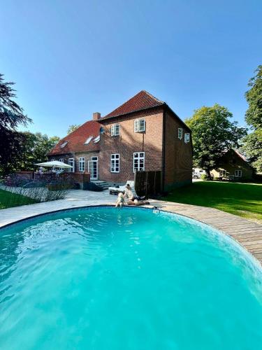 a large swimming pool in front of a house at Birkelund1927 in Dannemare