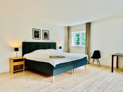 a bedroom with a large bed and a desk at Birkelund1927 in Dannemare