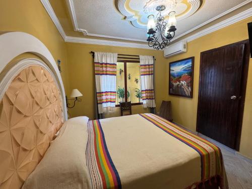 a bedroom with a bed and a chandelier at Hotel Boutique La Casa de María Joyita in Aguascalientes