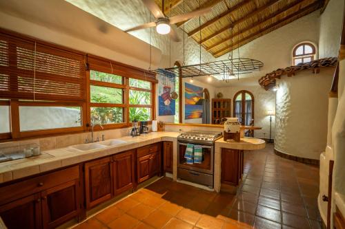 a large kitchen with a sink and a stove at Pelican Eyes Hotel and Resort in San Juan del Sur