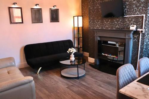 a living room with a couch and a fireplace at Blooming 2 bedroom Property in Beeston Hill