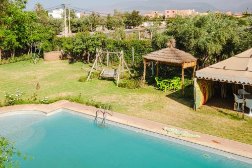 a backyard with a swimming pool and a playground at Villa with Private Garden & Pool Ourika, Atlas Mountains in Sidi Bouzguia