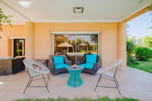 a patio with chairs and a table at Villa with Private Garden & Pool Ourika, Atlas Mountains in Sidi Bouzguia