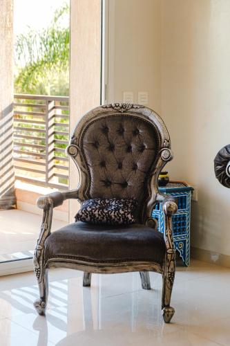 an old chair sitting in a room with a window at Villa with Private Garden & Pool Ourika, Atlas Mountains in Sidi Bouzguia