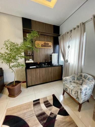 a living room with a chair and a table at Executivos Hotel in Cruz Alta