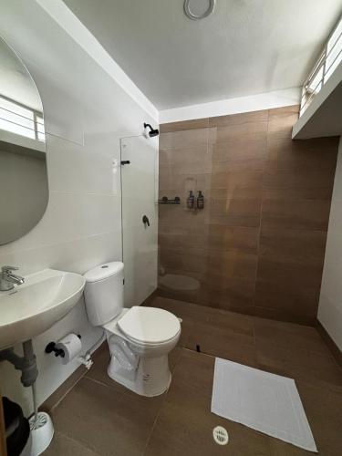 a bathroom with a toilet and a sink and a shower at PASANI - Casa de Huéspedes in Bucaramanga