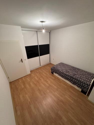 an empty room with a bed and a wooden floor at Modern stylish apartment in Kičevo