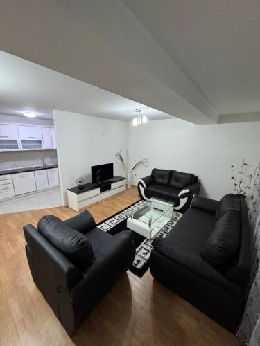 a living room with two black couches and a table at Modern stylish apartment in Kičevo