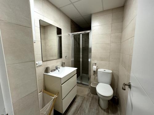 a bathroom with a toilet and a sink and a mirror at Apartamento Marinas de Nerja in Nerja