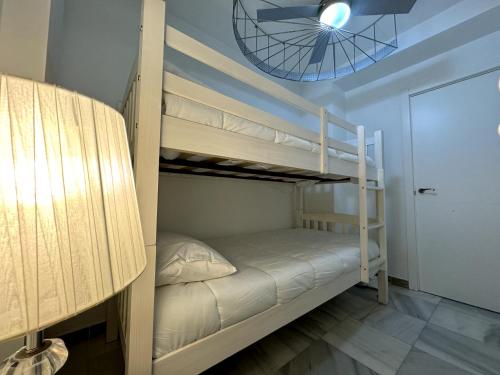 a bedroom with two bunk beds and a ceiling fan at Apartamento Marinas de Nerja in Nerja