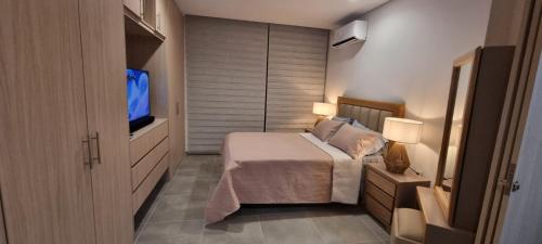 a bedroom with a bed and a flat screen tv at Salguero Suite in Gaira