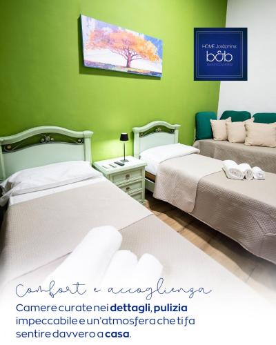 two beds in a room with green walls at Home Joséphine - CASERTA in Caserta