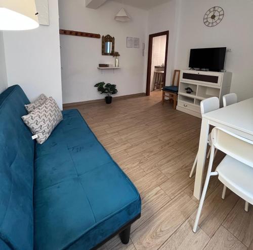 a living room with a blue couch and a table at El Atelier in Alcalá de Henares