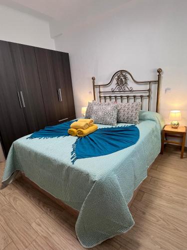 a bedroom with a large bed with a blue blanket at El Atelier in Alcalá de Henares