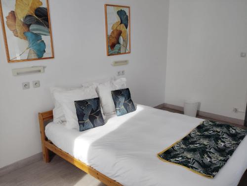 a bedroom with a white bed with two pillows at Ice Rock Hotel in LʼArgentière-la-Bessée