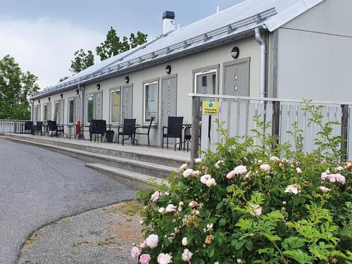a building with chairs and flowers in front of it at Venngarn 304 in Sigtuna