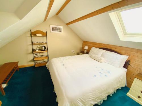 a bedroom with a large white bed in a attic at BallyV House: Private King Room with en-suite bathroom, breakfast, near Cliffs of Moher in Liscannor