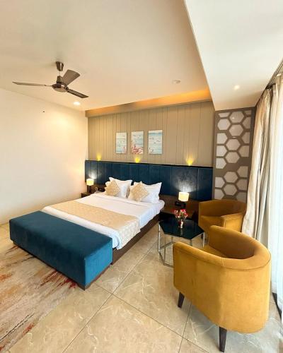 a bedroom with a bed and a couch and a chair at Hotel D Fairmount Plaza Near IGI in New Delhi