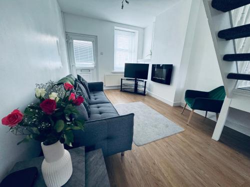 ホワイトヘイブンにあるHolly Terrace - 2 Bedrooms - Sleeps 3のリビングルーム(ソファ付)、バラの花瓶
