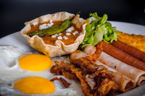 a plate of food with fried eggs and vegetables at La Siesta Hotel in Hermosillo