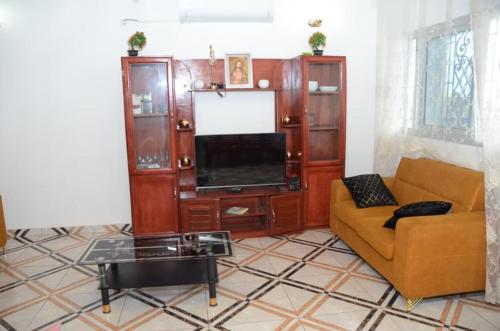 Una sala de estar con un sofá y un televisor. en Résidence DON BOSCO, en Douala