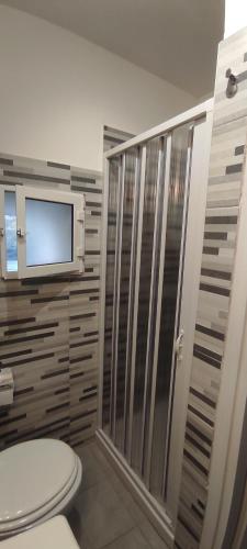 SonninoにあるRoom68のバスルーム(トイレ付)、壁にテレビが備わります。