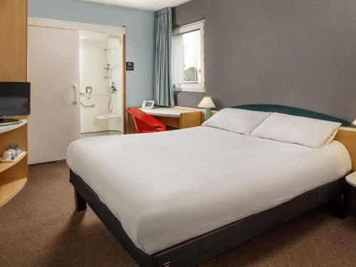 a hotel room with a large bed and a bathroom at ibis Hull City Centre in Hull