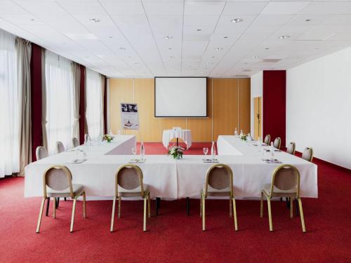 a conference room with a large white table and chairs at Mercure Nevers Pont De Loire in Nevers