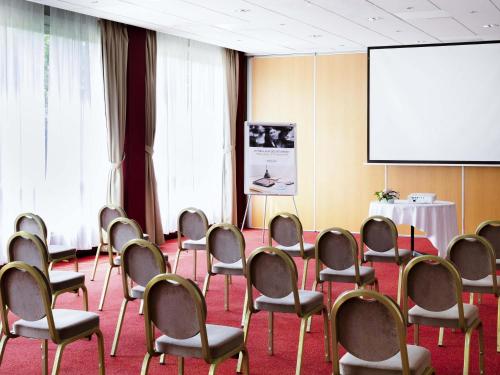 a conference room with chairs and a projection screen at Mercure Nevers Pont De Loire in Nevers
