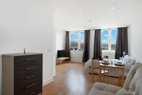 a living room with a couch and a table at Private Studio Apartment with Parking in Borehamwood